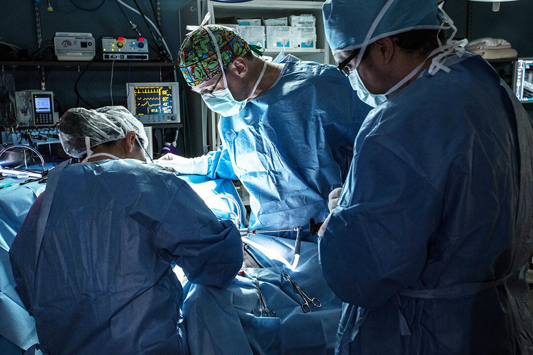 Three surgeons work together on a surgery.