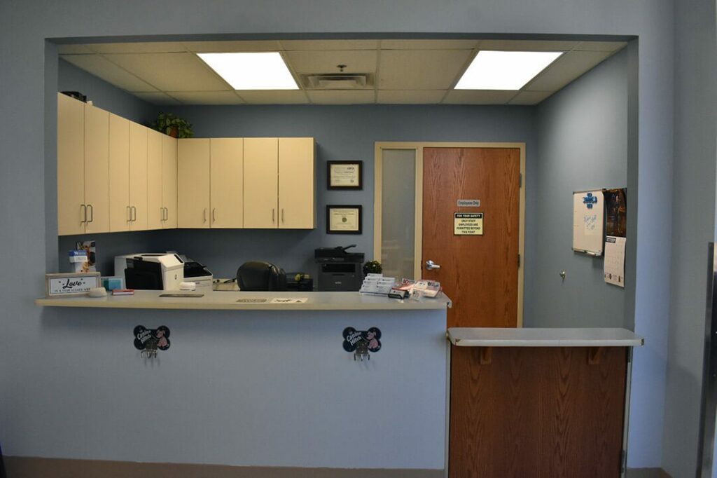 The receptionist desk has a counter in front and a door leading to the back.
