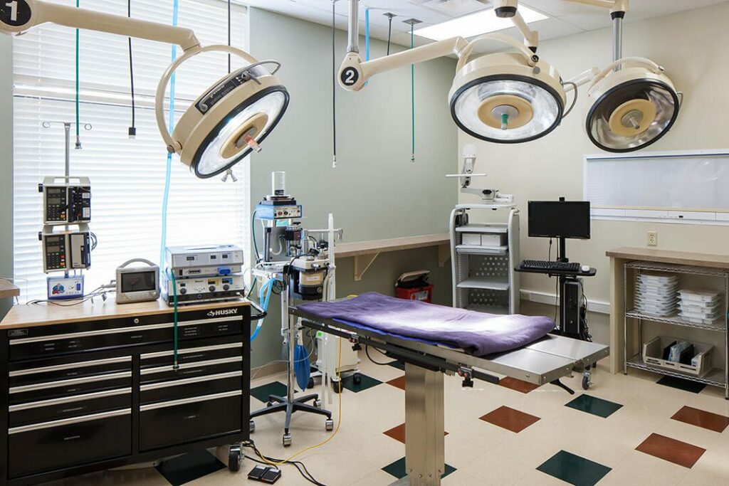 Surgery Suite with a table, three large lights and equipment.