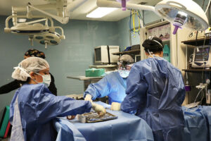 A group of surgeons work together on a patient. 