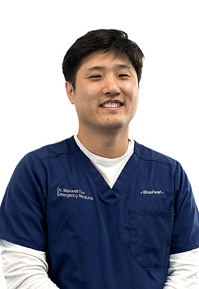 Dr. Maxwell Yim smiles for a professional headshot. He is wearing navy BluePearl scrubs that feature his name and specialty (Emergency Medicine).