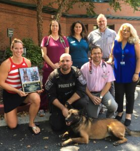 K9 Officer and handler give honorary plague to BluePearl Associates for exceptional care. 