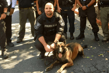 K9 Officer Indi and police squad stand with honorary plague.