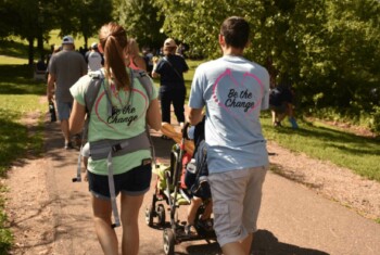 Two people walk down paved path for community walk fundraiser.