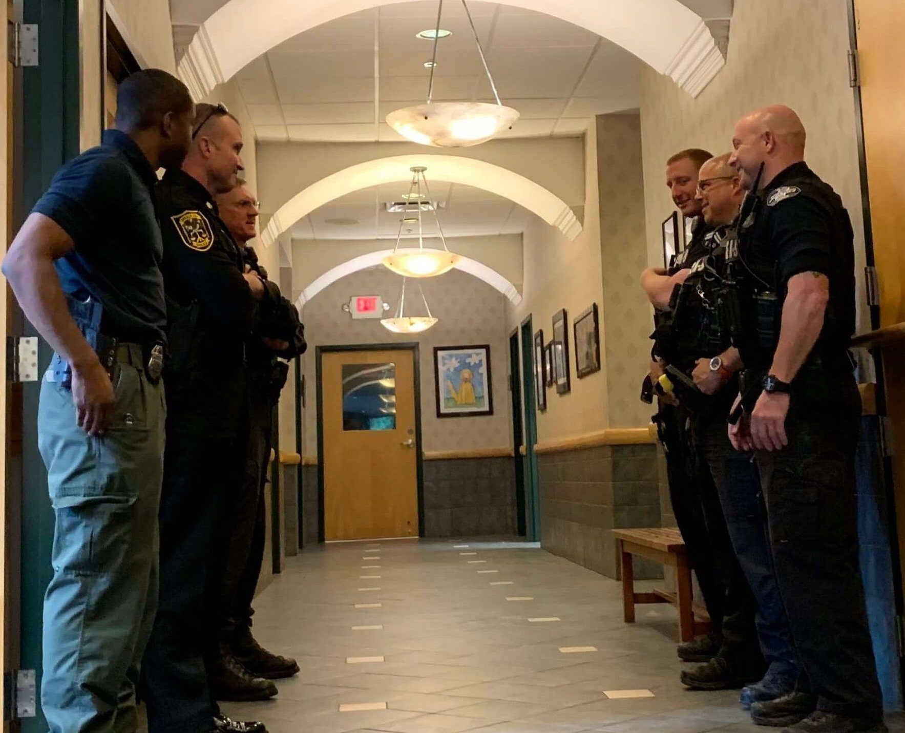 Officers wait in hallway of hospital.
