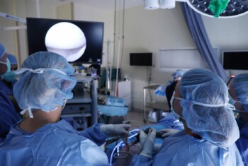 A team of surgeons use a scope to perform surgery.