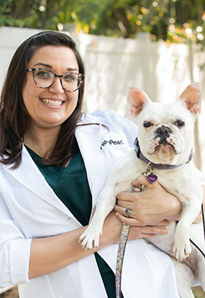 BluePearl board-certified surgeon, Christina Cramer holder her dog outside and smiling.