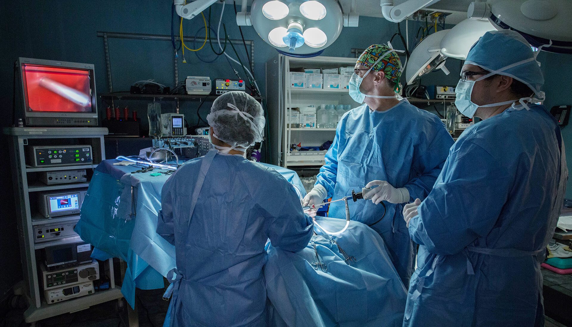 A team of surgeons use a scope during surgery.