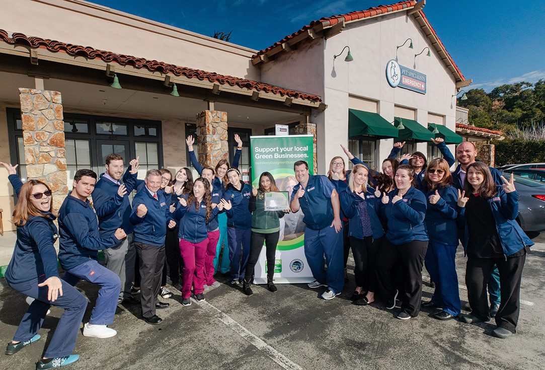 A pet hospital team stands outside the hospital entrance together.