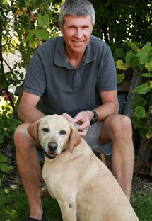 Dr. James Graham is an emergency medicine veterinarian. He is sitting next to a golden Labrador.