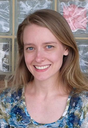 Dr. Casey Dignan smiling outside. She is in front of frosted glass squares.