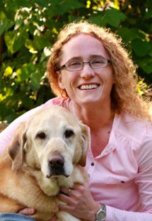 Dr. Shandy Chapin is an emergency medicine veterinarian. She has her arms around a Labrador.
