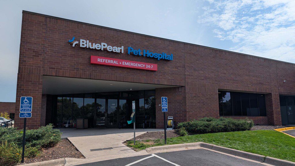 Entrance to pet hospital is at the corner of a brick building with signs on either side.