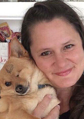 BluePearl emergency veterinarian, Tanía Power, smiling while holding her dog.