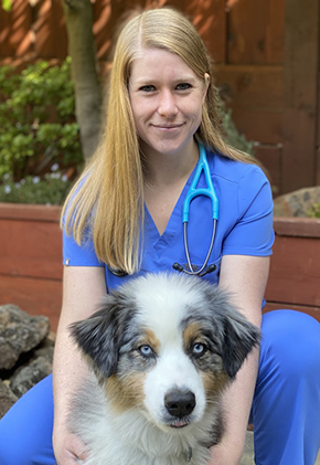 Dr. Aurora Stottler is a small animal medicine and surgery intern. She has her arms around a Australian shepherd.