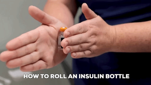 A vet tech rolls an insulin bottle between their hands.