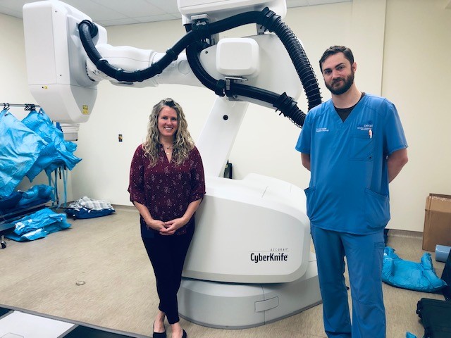 Clinicians standing with the Cyberknife equipment at the BluePearl Veterinary CyberKnife Cancer Center