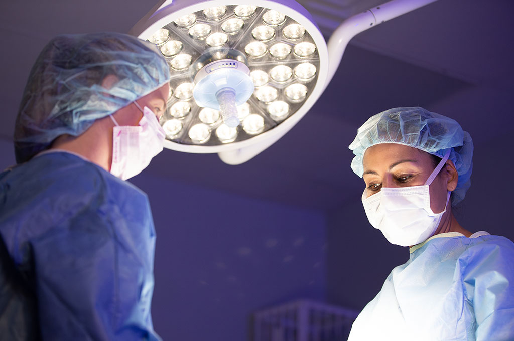 Dr. Leslie Thomas in a surgery, lit by an overhead light.