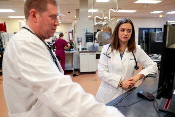Two veterinarians examine the readout of a diagnostic test in an animal hospital.