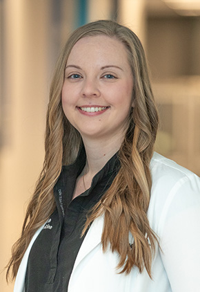 Dr. Lauren Plath smiling in the lobby of the Grand Rapids hospital. She has on her BluePearl white coat and a black top.