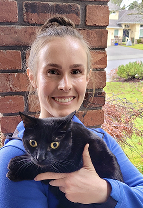 Dr. Teryn Bouché smiling and holding a black cat.