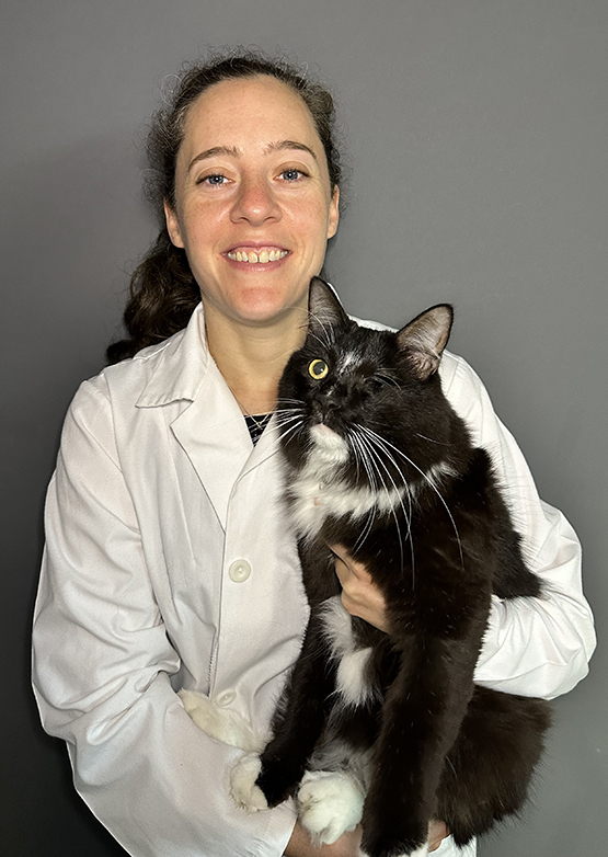 BluePearl's board-certified Ophthalmologist, Megan Cullen, holding her black cat and smiling.