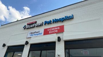 Signs on the outside of an off-white building read: BluePearl Pet Hospital Urgent Care.