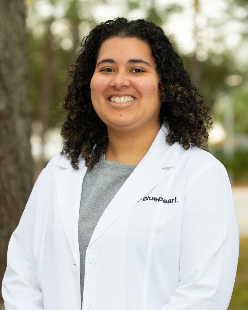 Dr. Morgan Davis smiling outside in her BluePearl white coat and grey top.