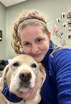 Blood Bank Certified Vet Tech Allison Kwasek smiling for a selfie with a yellow lab mix.