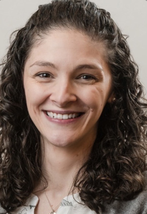 Dr. Juliet Armstrong smiling for a professional headshot in front of a grey backdrop.