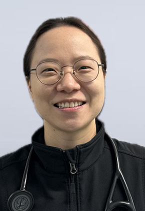 Dr. Hyein Jung, wearing glasses and a black jacket with a stethoscope around her neck, smiling in front of a light gray background.