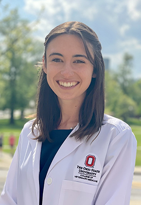 Dr. Kennedy Adams smiling outside on a college campus while wearing a black top and her Ohio State University whitecoat.
