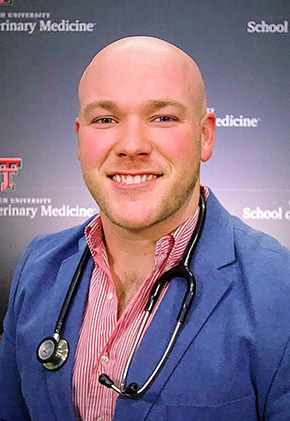 Dr. Austin Byrd smiling in front of a Texas Tech University School of Veterinary Medicine backdrop. He has on a blue sport coat, a button-down with small red and white stripes and a stethoscope around his neck.
