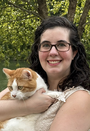 Dr. Brooke Salehzade smiles outside while holding her white and orange cat.