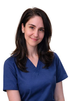 Dr. Jennifer Leos smiles for a professional headshot. She is wearing navy scrubs.