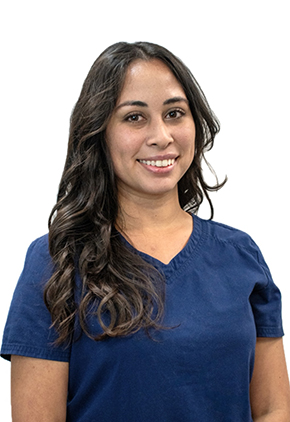 Dr. Jacqueline Hansen smiles for a professional headshot in front of a white background. She is wearing navy blue scrubs.