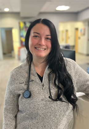 Dr. Samantha Smotherman smiles for a headshot in the lobby of BluePearl Reno. She is wearing a heather grey quarter-zip and has a stethoscope around her neck.