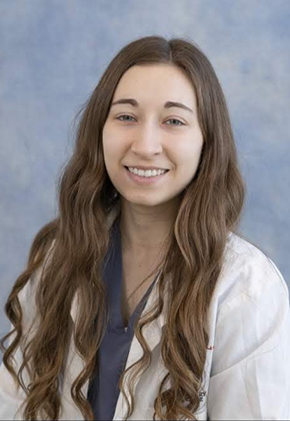 Dr. Marissa Zerkowski smiles for a professional headshot. She is wearing blue-grey scrubs and a whitecoat.