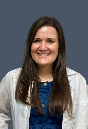 Dr. Amy Sheil smiles for a professional headshot. She is wearing her whitecoat.