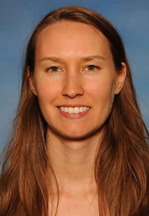 Dr. Kellie Holden smiles for a professional headshot in front of a blue background.