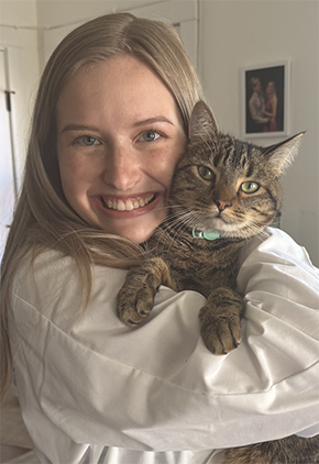 Dr. Katelyn Cadwallader smiles while holding her tabby cat.