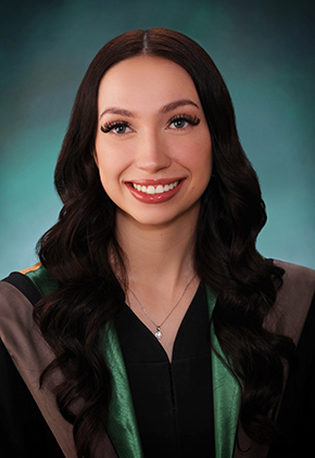 Dr. Hannah Squires-Bavis smiles for a professional studio graduation photo. She is wearing black doctoral robes that feature a green accent color.