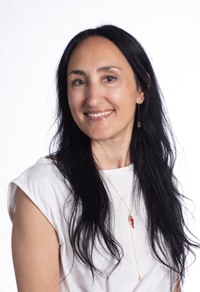 Dr. Antonella Borgatti smiles for a professional headshot in front of a white background. She is wearing a white blouse and has a small necklace with gold chain and red jewel.
